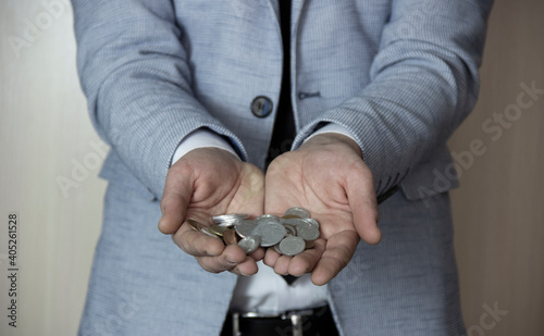 A businessman holds an coins .Elegantly dressed man.