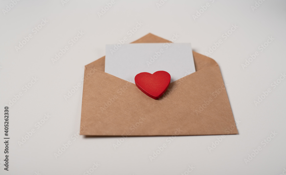 Woman's hands holding a letter in craft envelope on the rose background. Valentine's day concept. Space for text. Woman's hands holding a letter in craft envelope on the rose background. Valentine's day concept. Space for text.