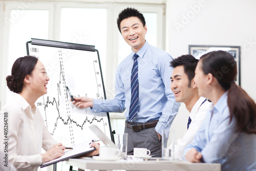 Businessman pointing at graph during presentation in boardroom