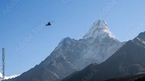 Ama Dablam peak with a rescue helicopter flying nearby, Nepal