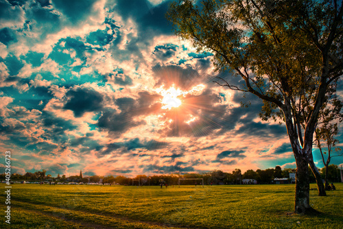 beautiful sunset sky with clouds in the field with green meadow