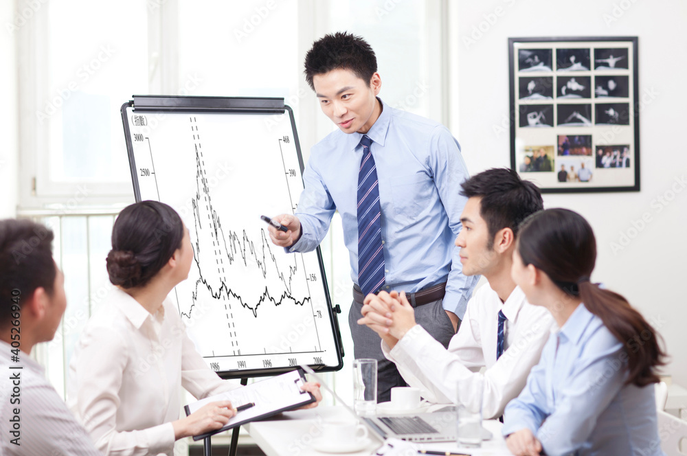 A young Man giving presentation to co-workers A young Man giving presentation to co-workers