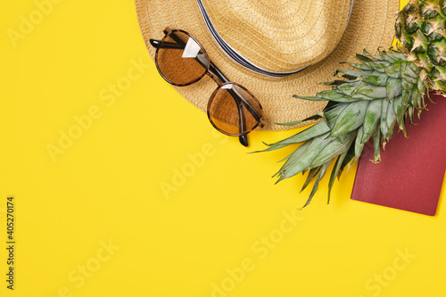 pineapple  hat  sunglasses and international passport on yellow background tropics vacation concept