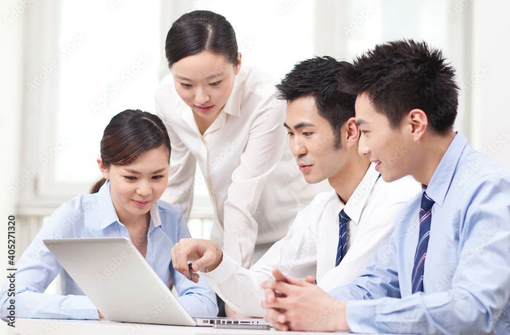 Group of businesspeople discussing working on computer Group of businesspeople discussing working on computer