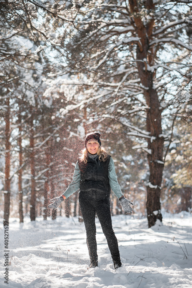Walking in snowy forest. Woman in wintertime outdoor.
