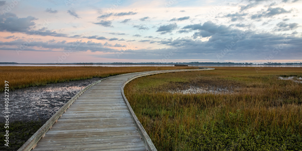 Scenic view of a boardwalk over the salt marsh at sunrise. 
