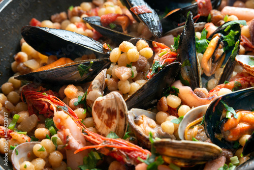 Piatto di deliziosa fregola con frutti di mare, cucina sarda di pesce, Cibo Italiano  photo