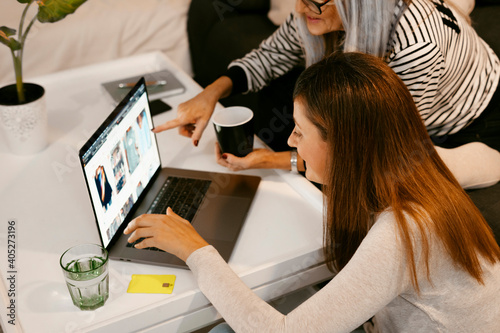 Women doing online shopping on laptop while sitting at home