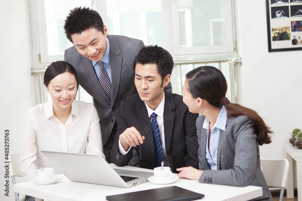Group of businesspeople discussing working on computer Group of businesspeople discussing working on computer