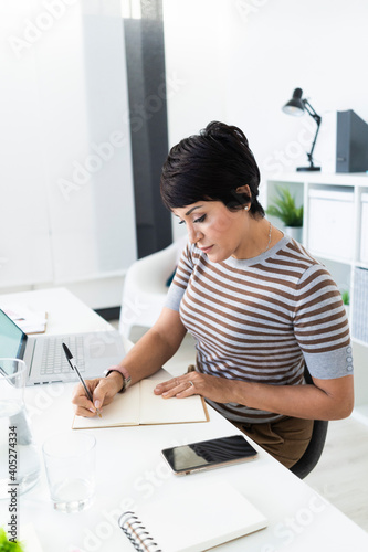 Portrait of businesswoman doing paperwork at office desk