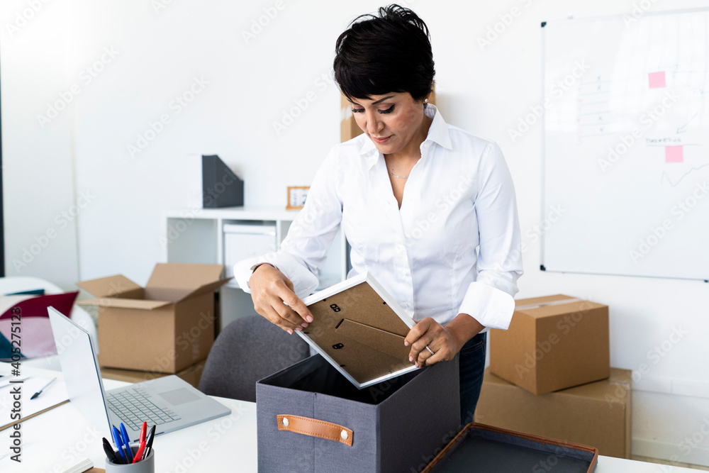 Businesswoman organizing office before relocation Businesswoman organizing office before relocation