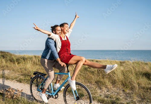 Carefree couple enjoying bicycle ride against clear sky photo