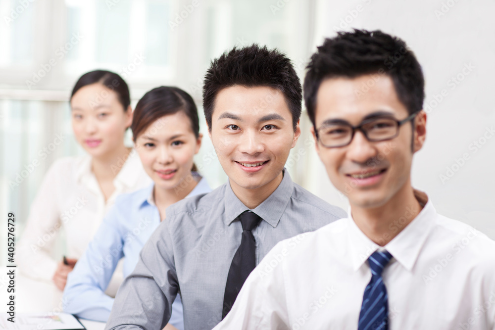 Executives sitting at conference table focus on woman in foreground Executives sitting at conference table focus on woman in foreground