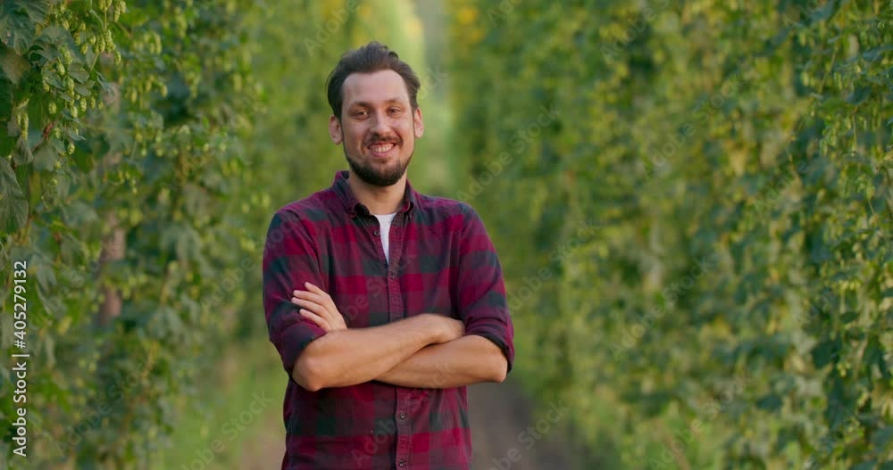 A portrait of a farmer folding his arms while standing in the hop field. A portrait of a farmer folding his arms while standing in the hop field.