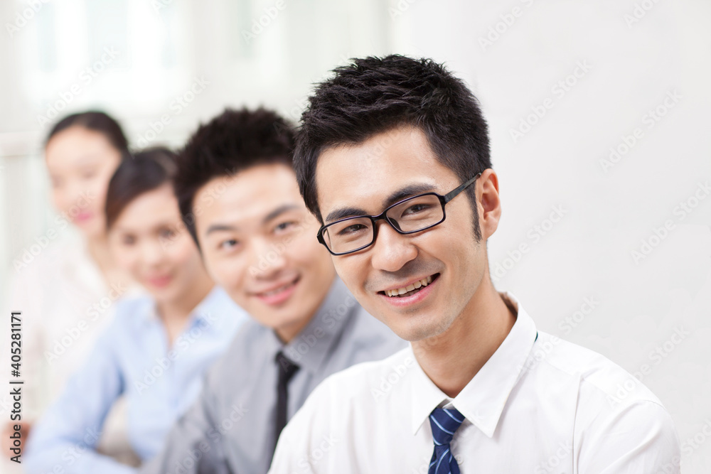 Executives sitting at conference table focus on woman in foreground Executives sitting at conference table focus on woman in foreground