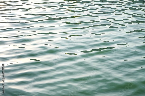 Blurred water surface with waves and green deep lake for background backdrop