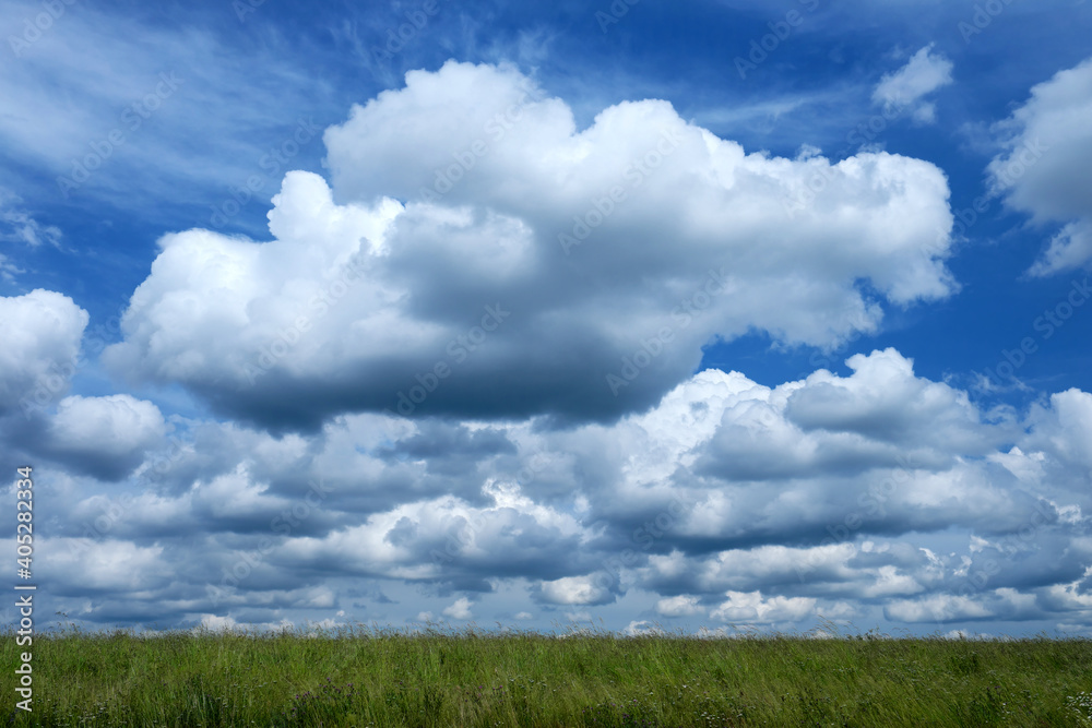 Cumulus-Wolken und blauer Himmel und ein Streifen hohes Gras - Stockfoto Cumulus-Wolken und blauer Himmel und ein Streifen hohes Gras - Stockfoto