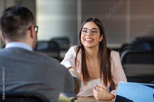 Successful job interview with boss and employee handshaking. Job applicants having interview. Smiling businesswoman shaking partners hand. oung woman arriving for a job interview.