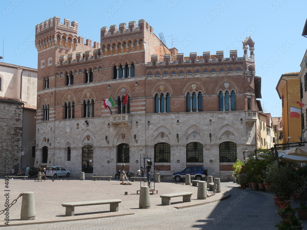 Aldobrandeschi Palace in Grosseto is a building with a gothic facade built of travertine and bricks and towers decorated by ogival mullioned windows and merlons.