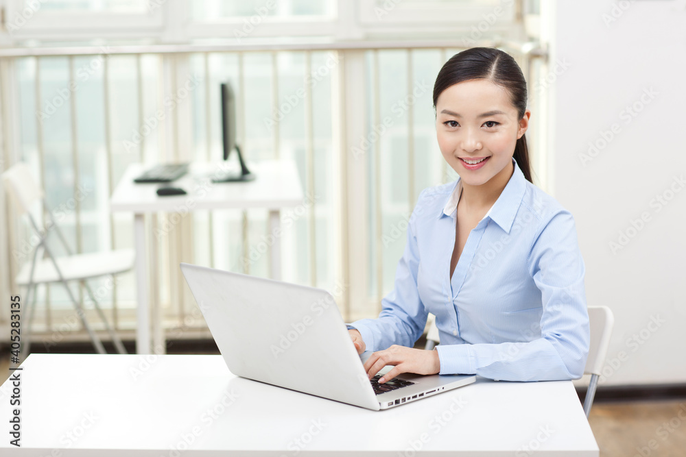 A Young woman using laptop in office A Young woman using laptop in office