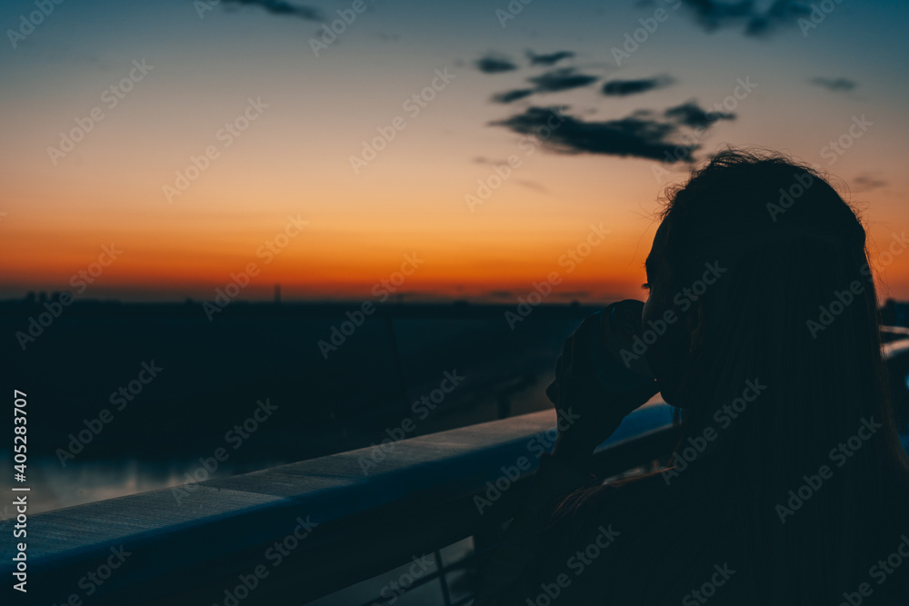 silhouette of a girl on the bridge meeting the dawn