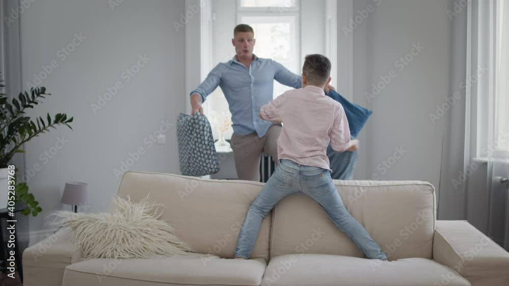 Dad And Son Are Fighting Pillows. They Play And Have Fun. Dad And Son Are Fighting Pillows. They Play And Have Fun.