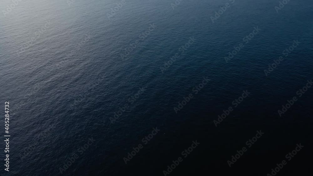 Flying over the blue surface of the sea or ocean