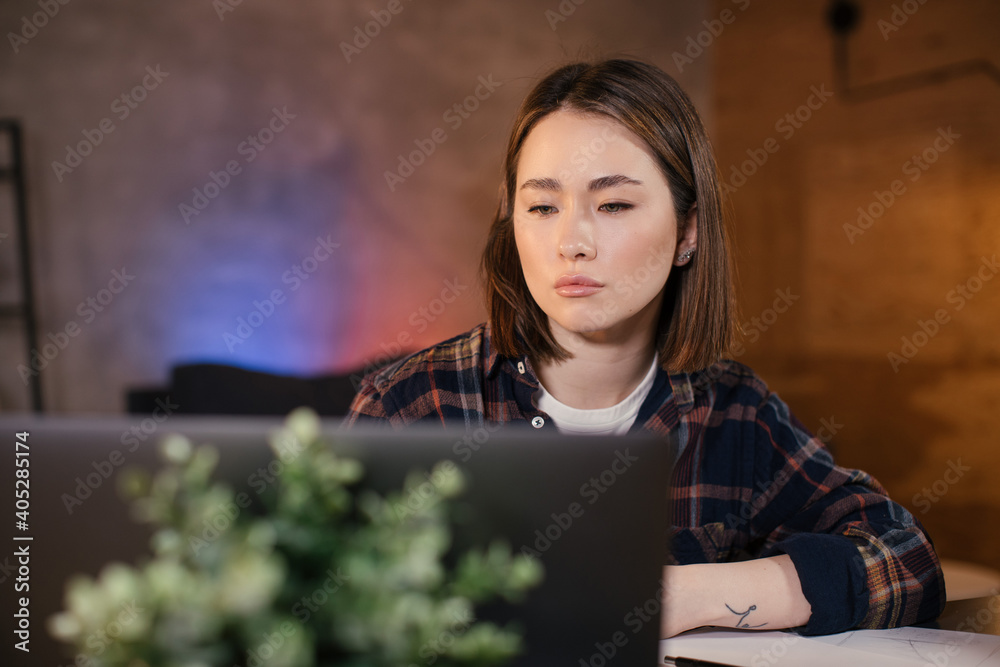 Asian girl trader working on a laptop at home Asian girl trader working on a laptop at home