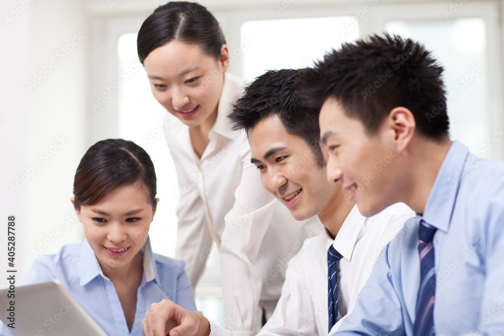 Group of businesspeople discussing working on computer Group of businesspeople discussing working on computer