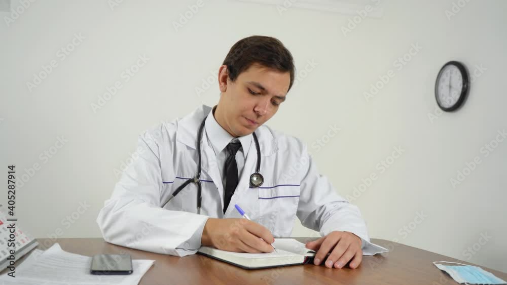 the doctor fills out paper while sitting in the office the doctor fills out paper while sitting in the office