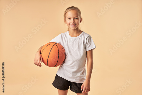 Cheerful girl basketball player holding game ball © Friends Stock