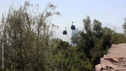 Cable cars crossing at San Cristobal mountain in Santiago, Chile. Aerial tramway transportation on sunny day