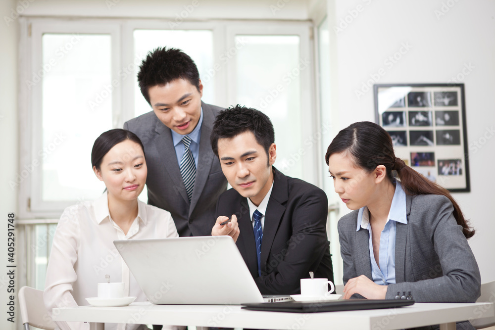 Group of businesspeople discussing working on computer Group of businesspeople discussing working on computer