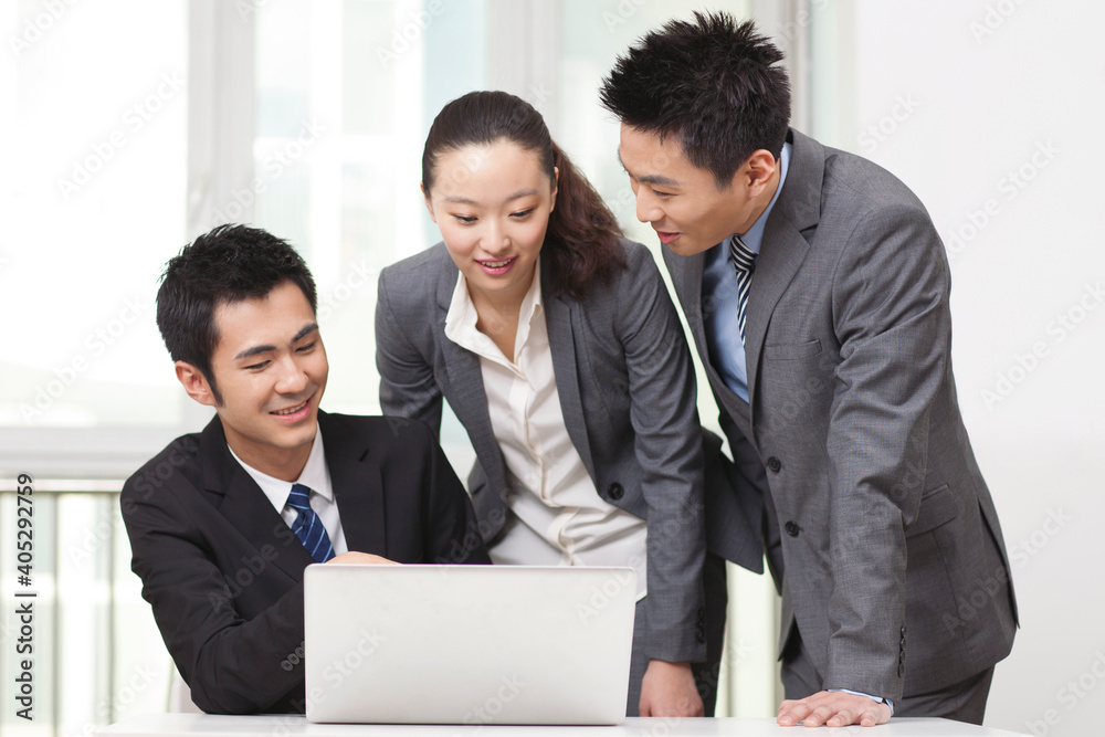 Group of businesspeople discussing working on computer Group of businesspeople discussing working on computer