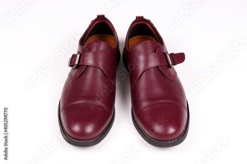 A pair of burgundy single monk strap shoes isolated on white background. Versatile business casual dress shoes without laces. Top view, copy space for text, flat lay.
