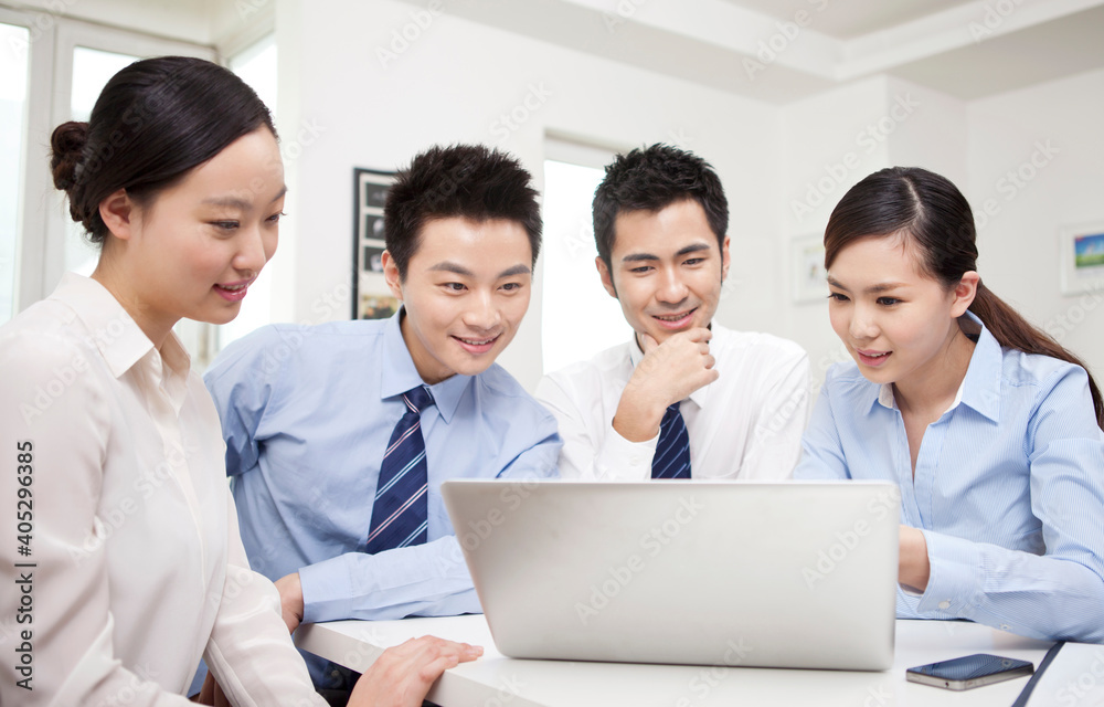 Group of businesspeople discussing working on computer Group of businesspeople discussing working on computer