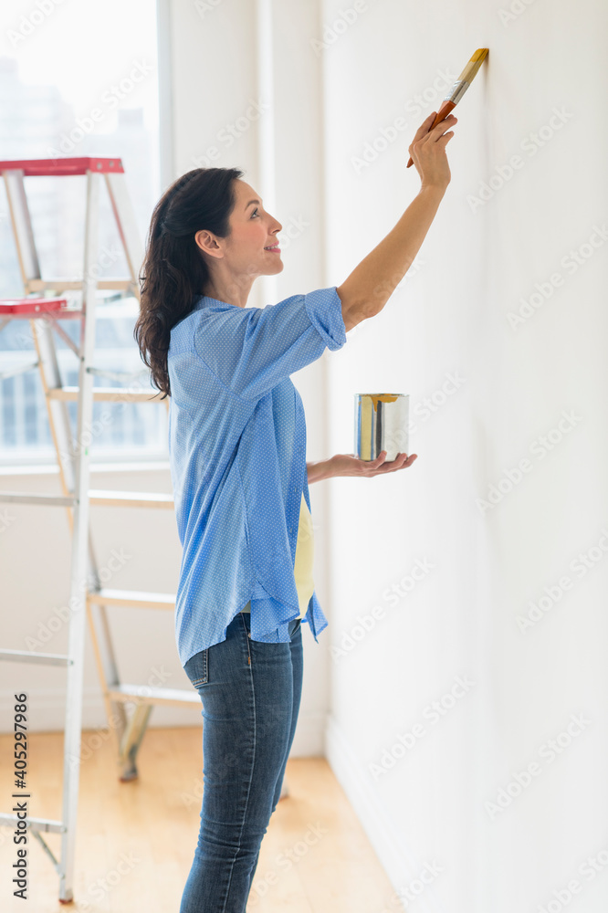 Woman painting wall at home