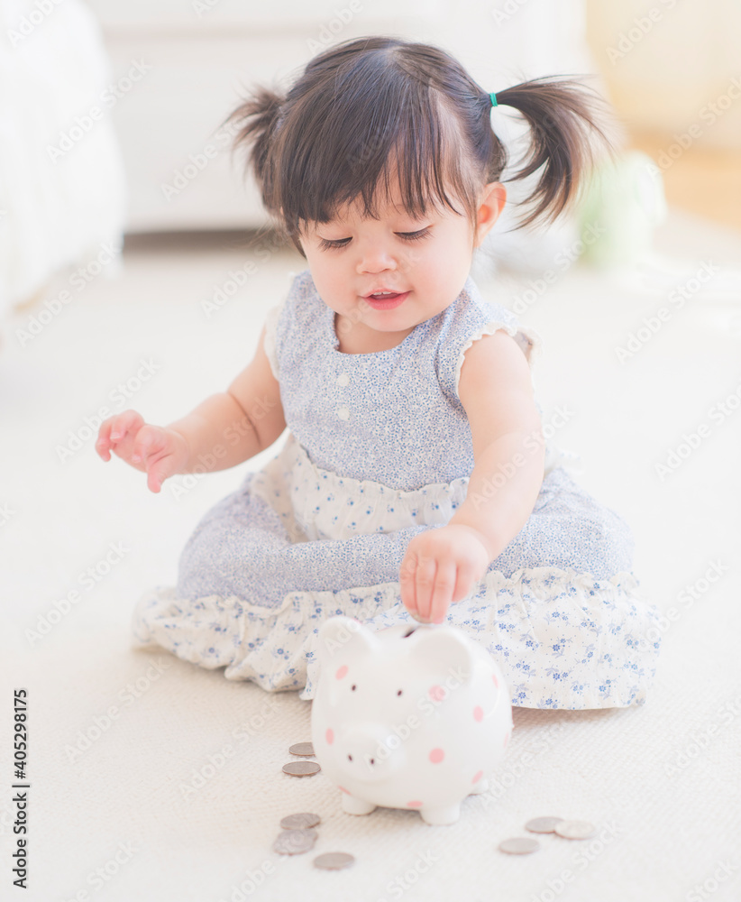 Portrait of baby girl (12-17 months) playing with piggy bank Portrait of baby girl (12-17 months) playing with piggy bank