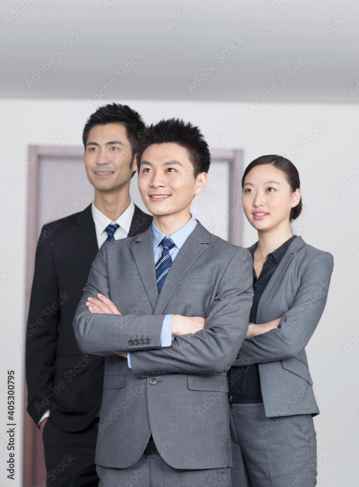 Four young office workers with hands crossed indoors,portrait