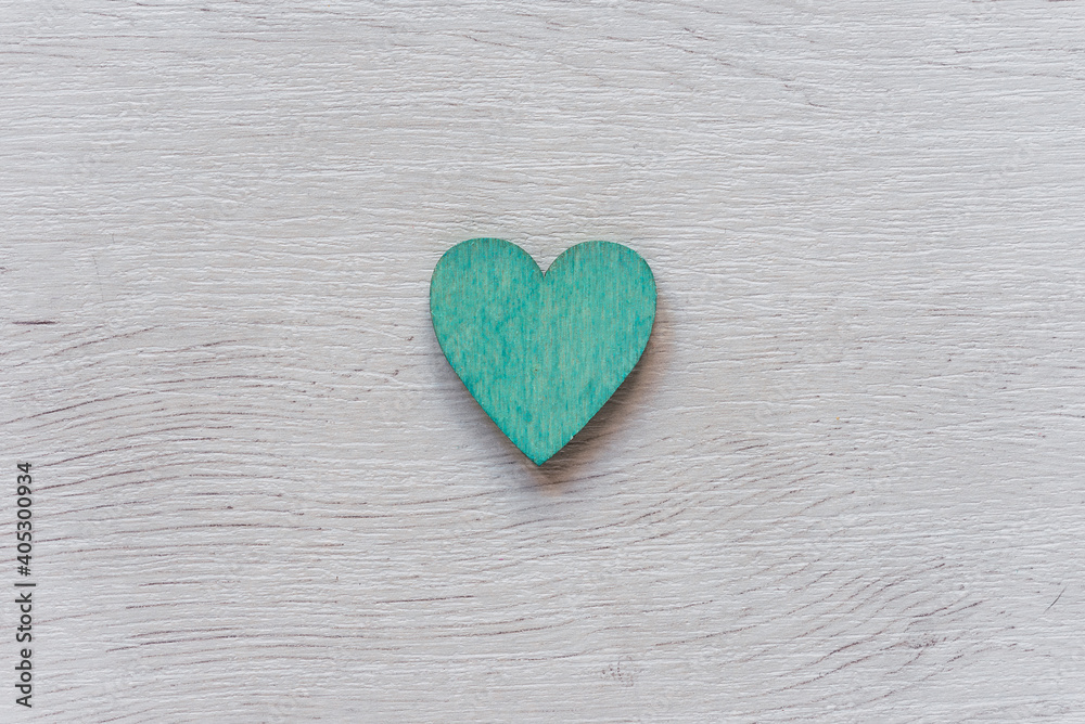 Obraz premium Green heart on wooden table