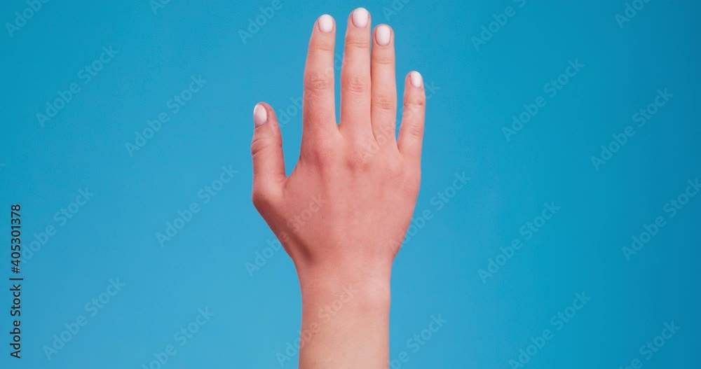 Joint disease. Sore female palm, pulsating with inflammation, blue studio background Joint disease. Sore female palm, pulsating with inflammation, blue studio background