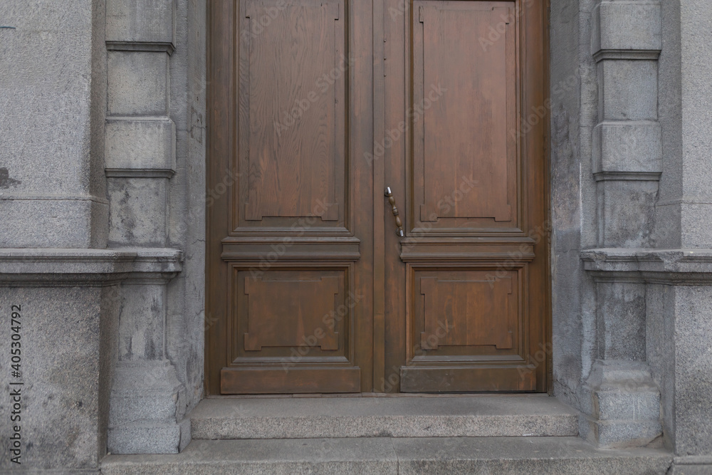 Brown historical wooden door. Abstract exterior and interior around the entrance. Doors of city houses.