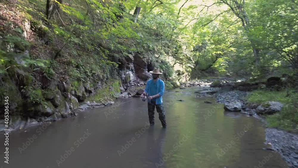 Fisherman are fishing in a mountain stream for brook trout. Fly Over River and Fishing Man. Trout fly fishing and catching. Fish Catch cinematic top view footage. High view. Fisherman are fishing in a mountain stream for brook trout. Fly Over River and Fishing Man. Trout fly fishing and catching. Fish Catch cinematic top view footage. High view.