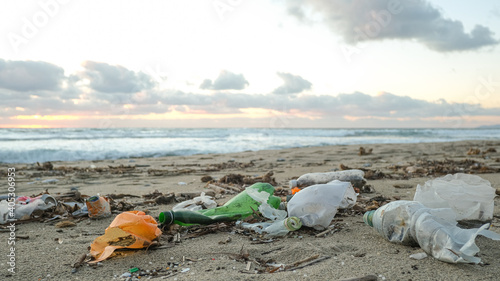Plastic bottles trash pollution on contaminated ocean sea coast,sunset time,environmental waste