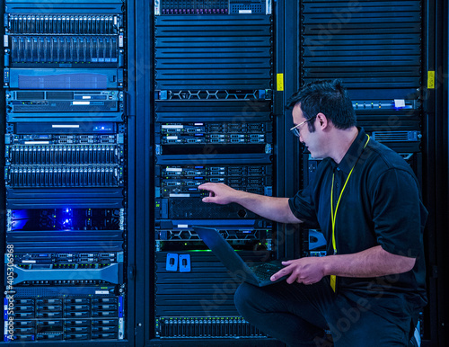 Employee pointing at server rack in data center photo