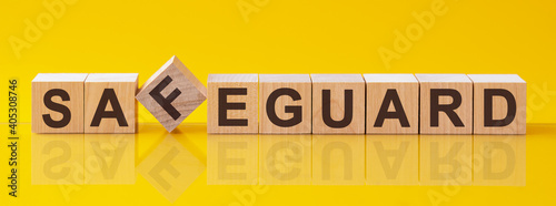 safeguard word is made of wooden building blocks lying on the yellow table, concept