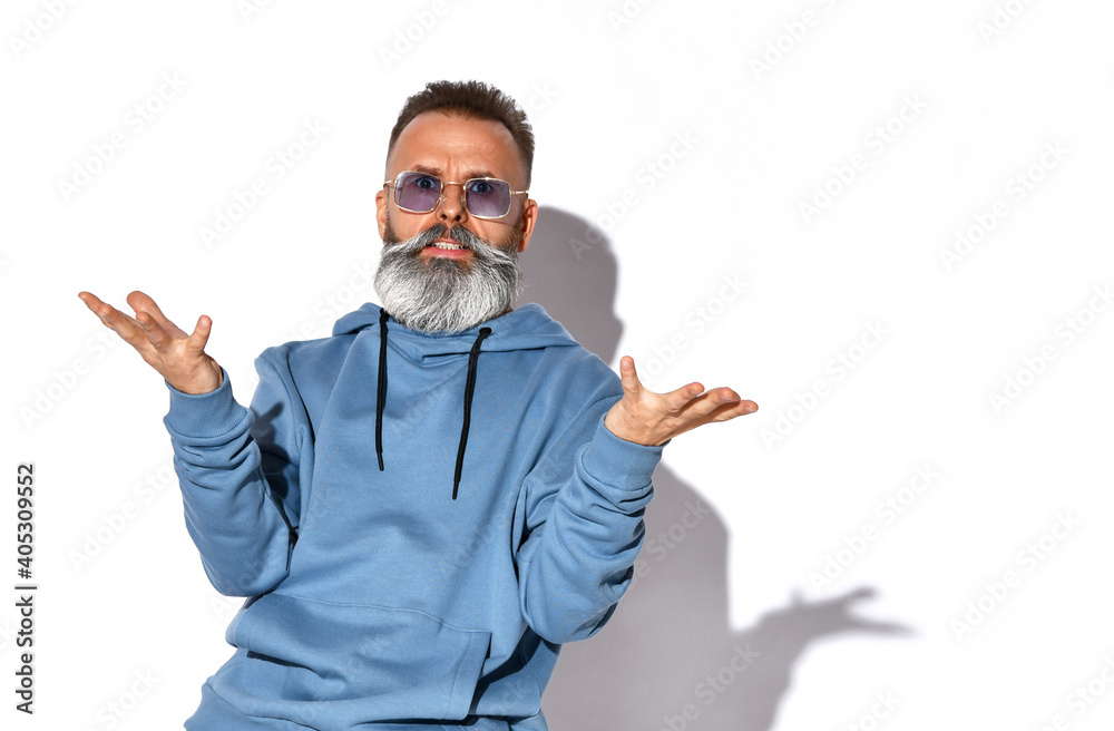 Annoyed emotional grey-haired bearded man in trendy sunglasses, casual sweatshirt looking at camera with irritated look. People, negative emotions and feelings. Studio shot isolated on white Annoyed emotional grey-haired bearded man in trendy sunglasses, casual sweatshirt looking at camera with irritated look. People, negative emotions and feelings. Studio shot isolated on white