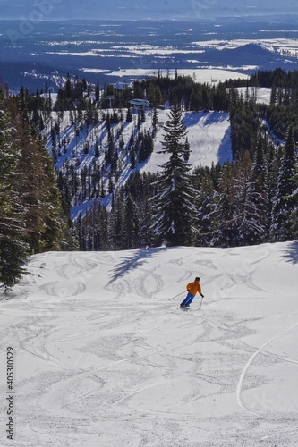skier on the downhill slope above a chair lift