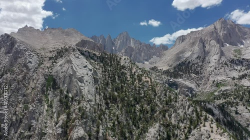 Mountain nature background. Highest mountain in California, Sierra Nevada peaks, USA. Mount Whitney view on summer day. Aerial 4K cinematic landscapes, bright blue sky and clouds on motion background
