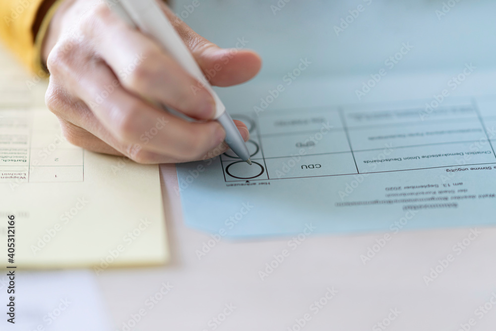 Close-up of woman filling voting ballot at home Close-up of woman filling voting ballot at home